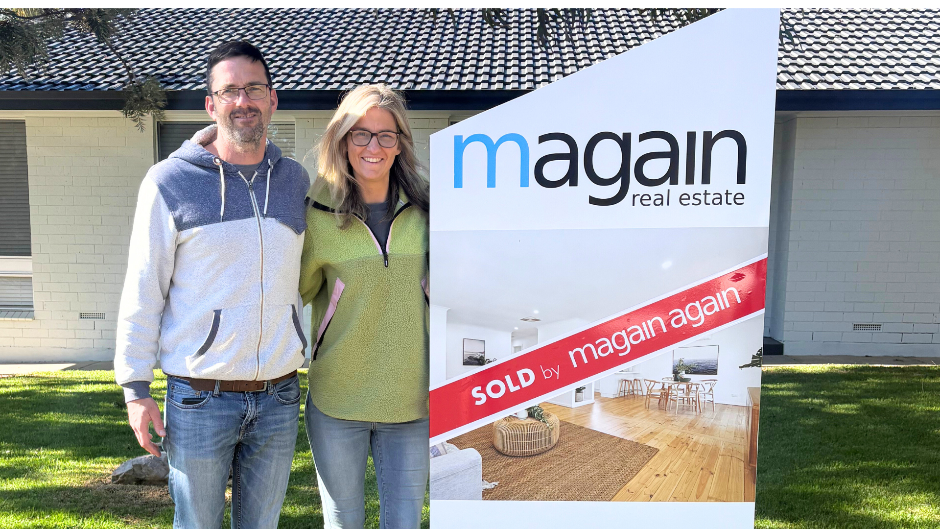 Carly and her husband celebrating their first property flip success with a sold sign after earning $95K profit in 84 days.