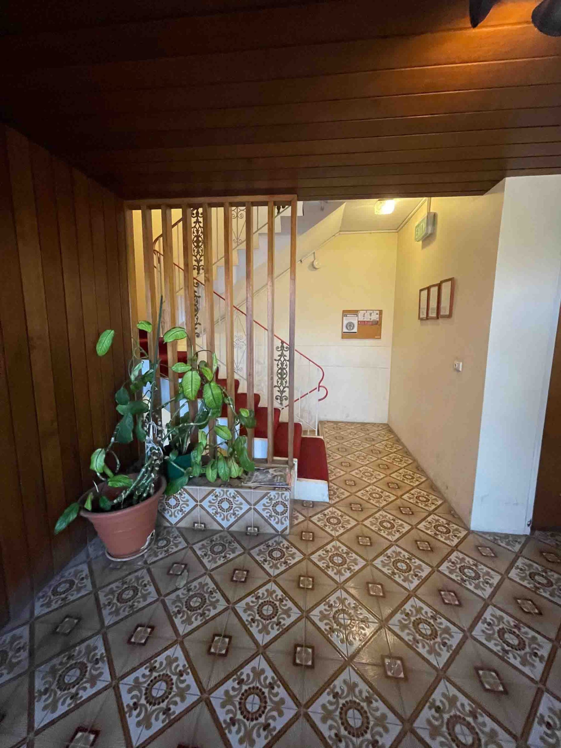 Before photo showing dated hallway tiles in strata building