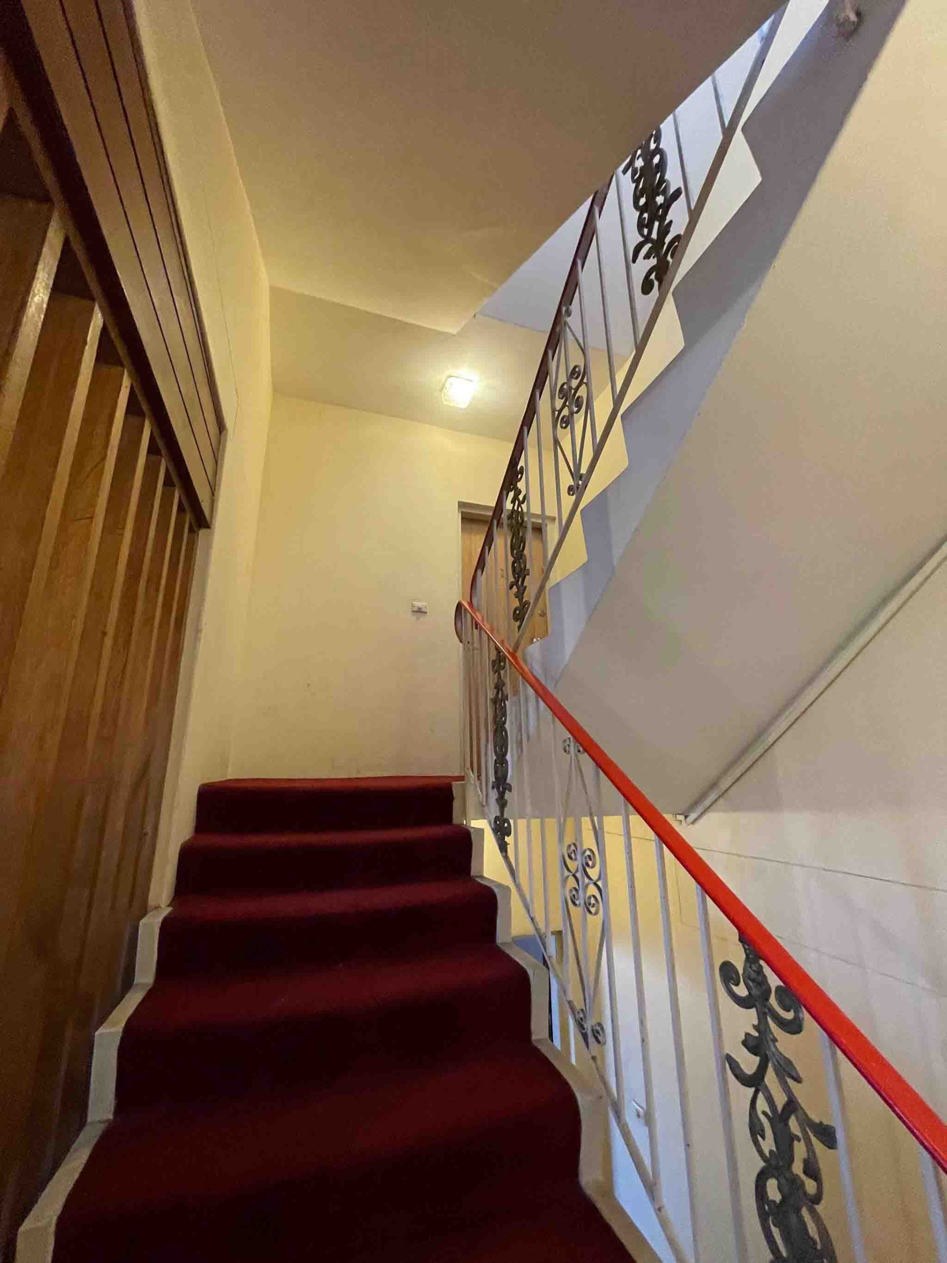Before photo showing old red carpeted stairs in Bondi strata building