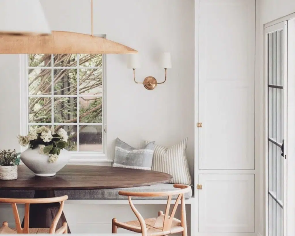 white banquette seating with round table and wall sconce
