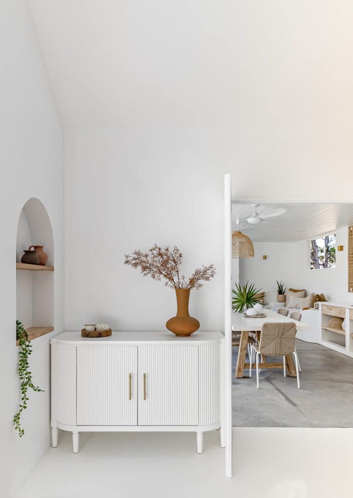 Minimalist entryway leading to a bright coastal dining and entertaining space.