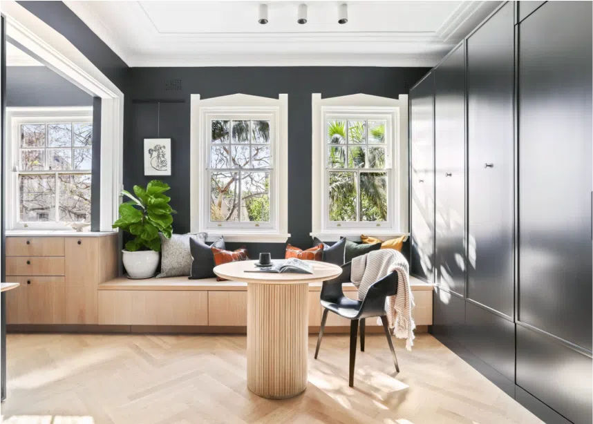 modern built-in banquette seating with black feature wall and storage