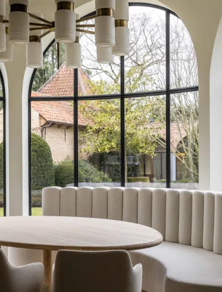 curved banquette seating under arched windows – neutral interior design