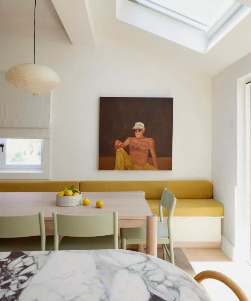 yellow banquette seating – cozy modern dining nook with skylight