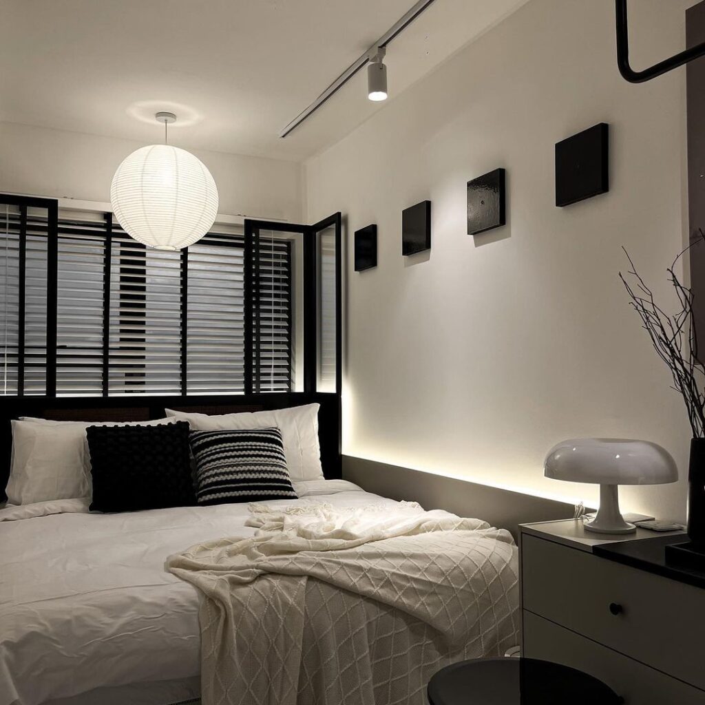 Small modern bedroom with paper lantern light and striped pillows