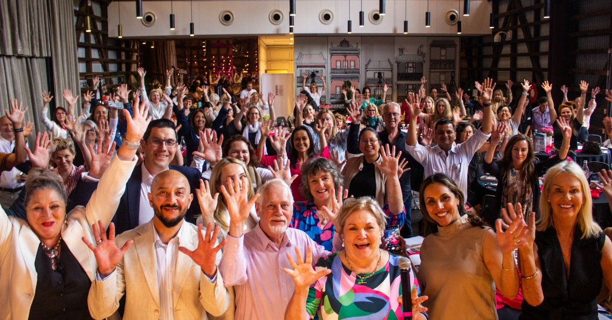 Bernadette Janson and a group of 'Wonder Women' renovators celebrating at a live workshop, demonstrating the community support available for women over 50 building wealth and financial independence through property renovation.