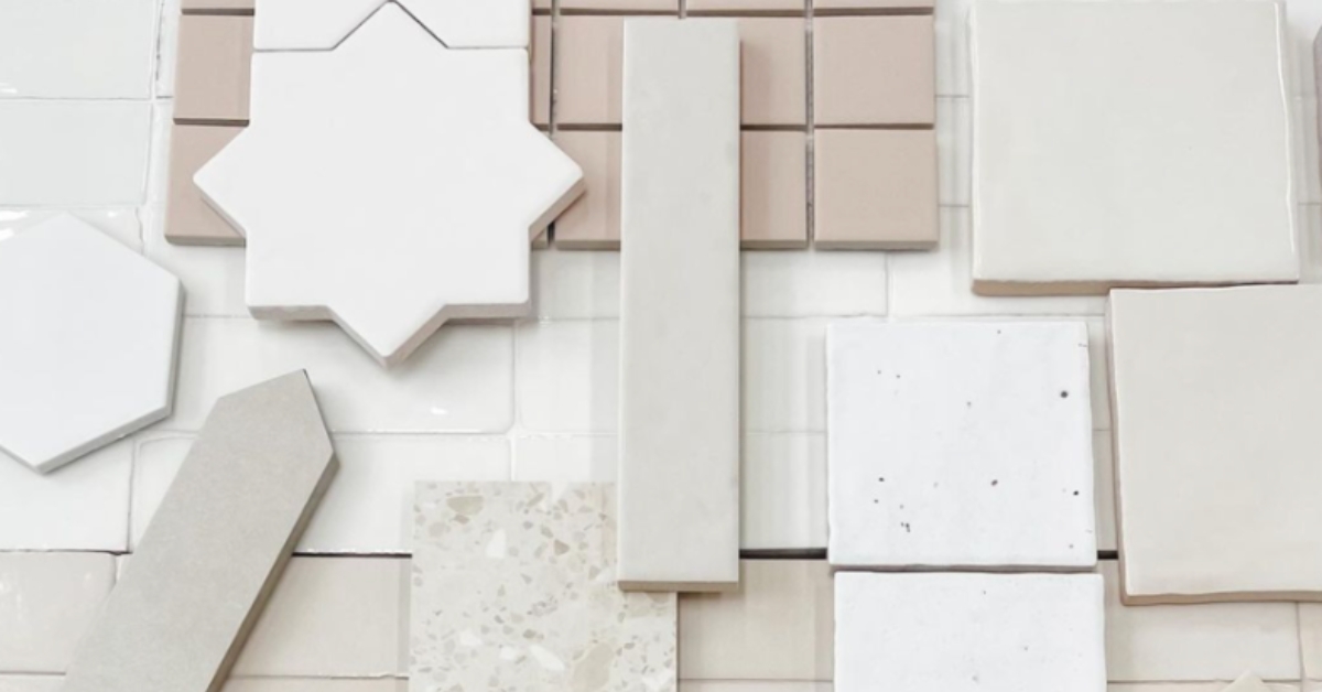 Flat lay of assorted ceramic tiles in white and beige tones featuring star, hexagon, and rectangular shapes, illustrating the material selection process for DIY property styling.