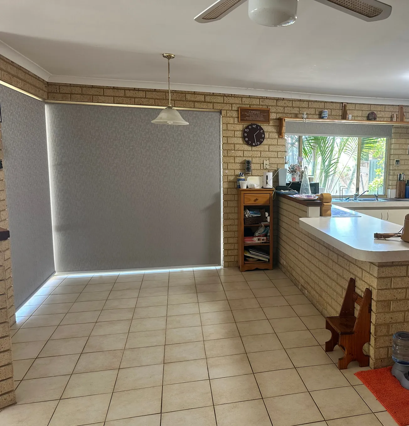 1980s kitchen and dining area with exposed brick walls, a brick breakfast bar and beige floor tiles before the renovation